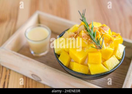 Glace rasée à la mangue fraîche de style coréen sur une table en bois . Banque D'Images