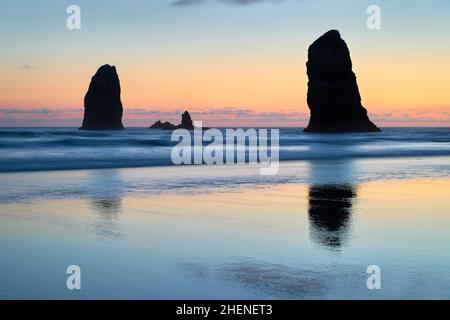The Needles et Surf Cannon Beach.Coucher de soleil à The Needles à Cannon Beach, Oregon, tandis que les vagues se délaguent sur la plage.États-Unis. Banque D'Images