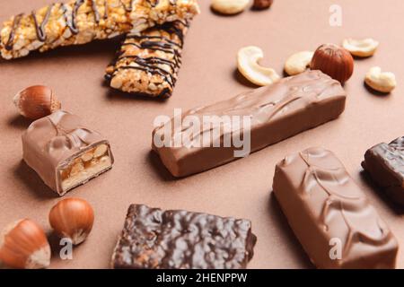De savoureuses barres de noix de chocolat sur fond de couleur Banque D'Images