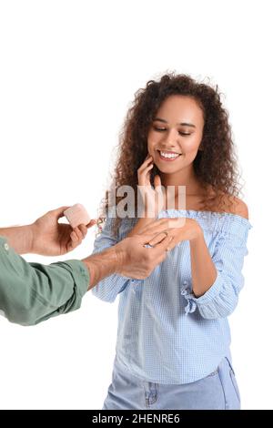 Jeune homme proposant à sa petite amie sur fond blanc Banque D'Images