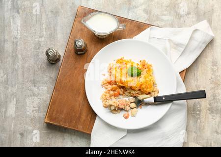 Assiette avec tarte au poisson anglais savoureuse sur fond gris Banque D'Images