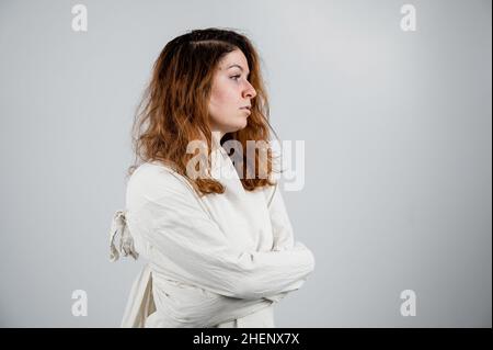 Portrait en gros plan d'une femme aliénée en blouson sur fond blanc. Banque D'Images