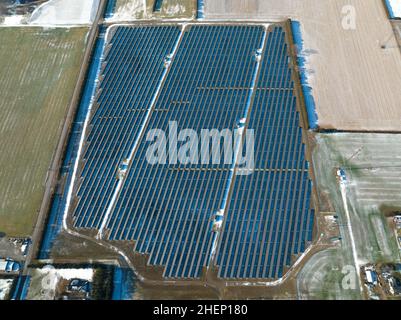 Une vue aérienne au-dessus d'une ferme solaire rurale par une journée ensoleillée d'hiver. Banque D'Images