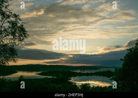 Coucher de soleil nuageux sur le Loch Shuna en Écosse.Coucher de soleil sur le Loch Shuna à Craobh Haven, Argyll et Bute en Écosse. Banque D'Images