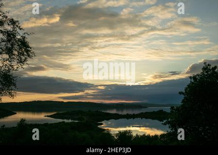 Coucher de soleil nuageux sur le Loch Shuna en Écosse.Coucher de soleil sur le Loch Shuna à Craobh Haven, Argyll et Bute en Écosse. Banque D'Images