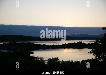 Coucher de soleil nuageux sur le Loch Shuna en Écosse.Coucher de soleil sur le Loch Shuna à Craobh Haven, Argyll et Bute en Écosse. Banque D'Images