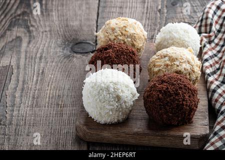 Boules de chocolat et de noix de coco faites maison sur une table en bois Banque D'Images
