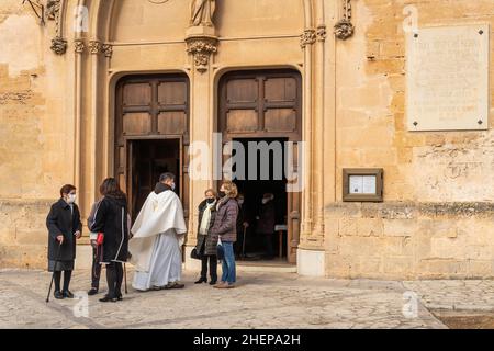 Petra, Espagne; janvier 09 2022: Façade principale de l'église paroissiale de Sant Pere, située dans la ville de Majorcan de Pétra.Paroissiens et curé de paroisse sa Banque D'Images