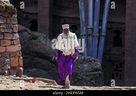 Ancien prêtre éthiopien dans les vêtements traditionnels allant à l'Église pour prier Banque D'Images