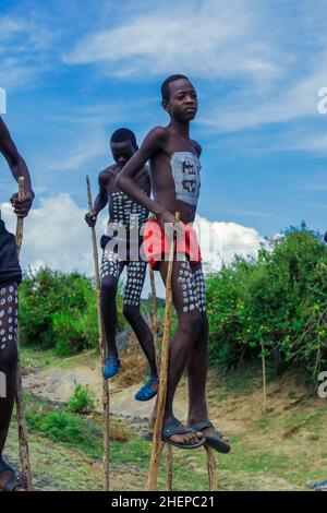 Jeunes garçons de la tribu de Benna avec la peinture traditionnelle de corps sur les longues bâtons de bois posant pour l'image Banque D'Images