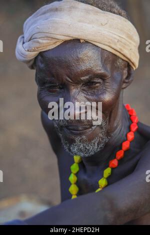 Dassanech Tribe Old Man avec collier lumineux traditionnel et Turban blanc dans le village local Banque D'Images