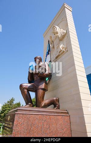 Soldat à genoux en bronze avec drapeau, partie de la statue de l'Oath de la mère patrie.Au Musée d'État des forces armées de la République d'Ouzbékistan Banque D'Images