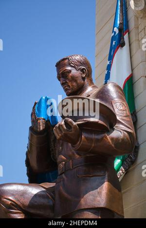 Soldat à genoux en bronze avec drapeau, partie de la statue de l'Oath de la mère patrie.Au Musée d'État des forces armées de la République d'Ouzbékistan Banque D'Images