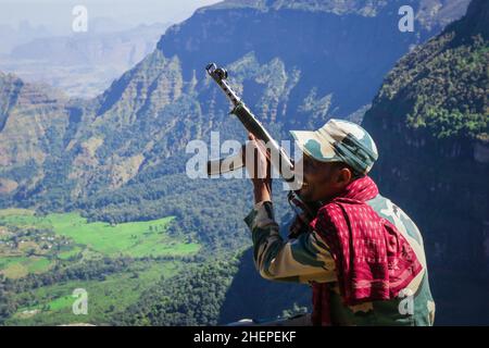 Escorte Man avec le canon posant avec la vallée verte des montagnes Simien Banque D'Images