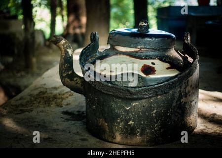 Gros plan sur une bouilloire à thé métallique d'époque dans les zones rurales DE L'INDE. Banque D'Images