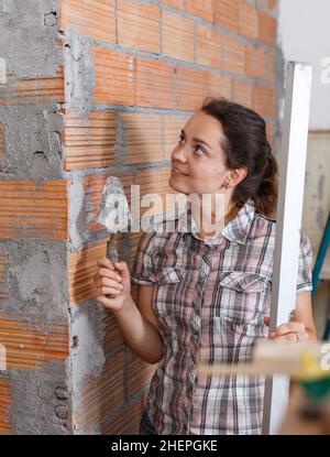 Femme travaillant avec une truelle plâtreuse Banque D'Images