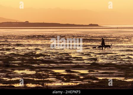 Coucher de soleil sur la plage de Hoylake sur la rivière Dee estrauary qui donne sur le pays de Galles au-dessus de l'île Hilbre. Banque D'Images