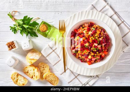 Vinegret, vinaigrette russe, salade de betteraves rouges cuites en dés, pommes de terre, carottes, oignons hachés, cornichons sautés,pois verts dans un bo blanc Banque D'Images