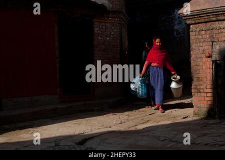 Une femme locale de nouvelle collecte de l'eau dans la ville de Bhaktapur, classée au patrimoine mondial de l'UNESCO, au Népal. Banque D'Images