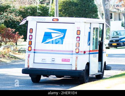 Babylone, New York, Etats-Unis - 12 décembre 2021 : un camion de livraison postale des etats-Unis est stationné dans une rue résidentielle de Babylone Village pendant que la poste Banque D'Images