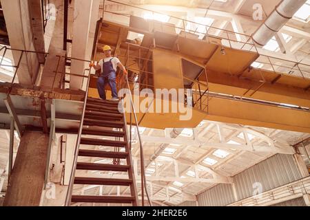 Un homme qui marche dans l'escalier de l'atelier d'ingénierie Banque D'Images