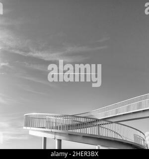 Une image en noir et blanc du pont de Gypsy entre Old Leigh et Chalkwell en face de la ligne de chemin de fer sur une matinée ensoleillée et lumineuse de janvier avec Contrail Banque D'Images