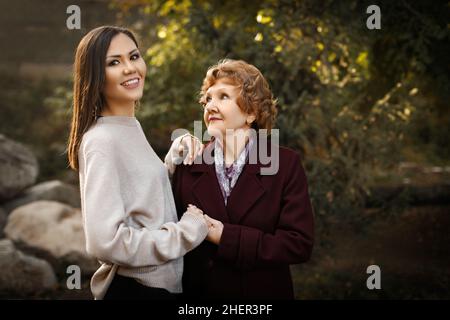 Bonne maman regardant la fille tenant les mains à l'extérieur dans le parc à l'extérieur.Photo de haute qualité Banque D'Images