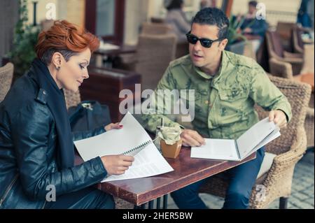 Jeune couple regardant le menu dans un restaurant Banque D'Images