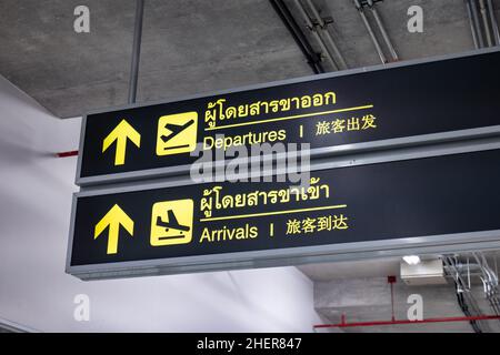 Panneau de départ et d'arrivée de l'aéroport.Tableau d'information sur le départ et l'arrivée des vols à l'aéroport écrit en anglais, chinois et thaïlandais Banque D'Images