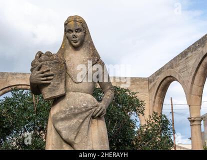 Petra, Espagne; janvier 09 2022: Sculpture en pierre symbolisant une pagesa majorquine, faite par Josep Gaya font, et située à l'extérieur du bâtiment de Th Banque D'Images