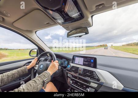 Belle vue de l'intérieur de la BMW iX3 sur la route.Conducteur femelle dans le véhicule.Suède.Uppsala. Banque D'Images