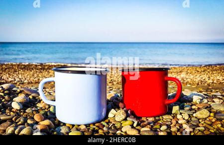 gros plan de coupes bleu clair et rouge sur les rochers de la plage avec mer calme en arrière-plan. Banque D'Images