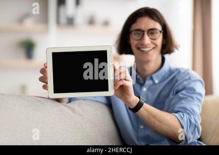 Image de maquette d'un type heureux montrant une tablette numérique avec écran vide pour l'application, la conception de site Web ou la publicité, espace libre Banque D'Images