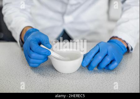 Le chimiste effectue une expérience avec de l'azote liquide dans un mortier de laboratoire avec pilon Banque D'Images