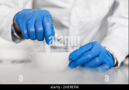 Le chimiste effectue une expérience avec de l'azote liquide dans un mortier de laboratoire avec pilon Banque D'Images