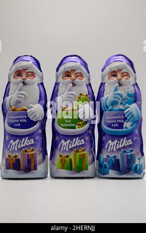 RHEINBACH, ALLEMAGNE 08 décembre 2020, trois clauses de Santa Milka violettes en différentes saveurs sur fond blanc Banque D'Images