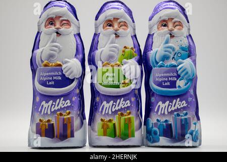 RHEINBACH, ALLEMAGNE 08 décembre 2020, trois clauses de Santa Milka violettes en différentes saveurs sur fond blanc Banque D'Images