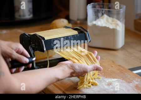 nouilles maison avec petite machine manuelle dans la cuisine avec farine Banque D'Images