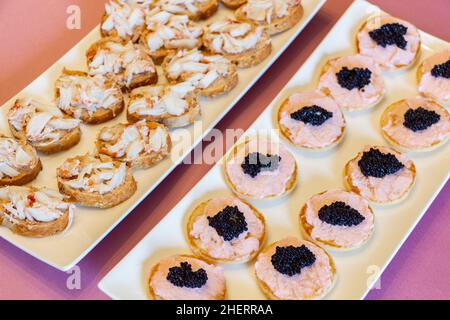 Blinis avec taramosalata, œufs de poisson en morceaux et homard comme apéritif pour un cocktail Banque D'Images