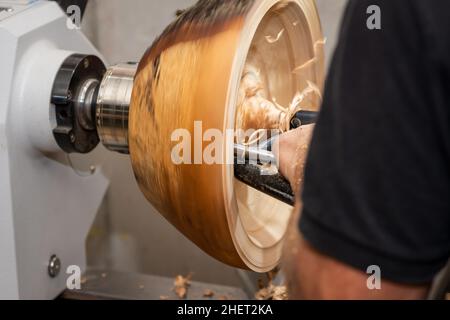 homme kaing tourniery de bol en bois avec burin et morceau de bois rotatif Banque D'Images