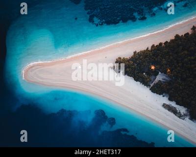 Vue de haut en bas de la célèbre plage de rats Zlatni à bol la nuit, les premiers feux sont sur, île de Brac, Croatie, Europe.Également appelé corne dorée ou cap doré.A Banque D'Images