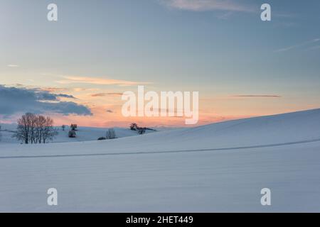 paysage d'hiver au coucher du soleil le soir et nuages lumineux Banque D'Images