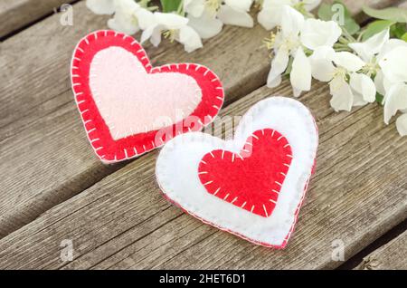 Carte de Saint-Valentin, deux coeurs sur fond de bois avec fleurs de pommier. Banque D'Images