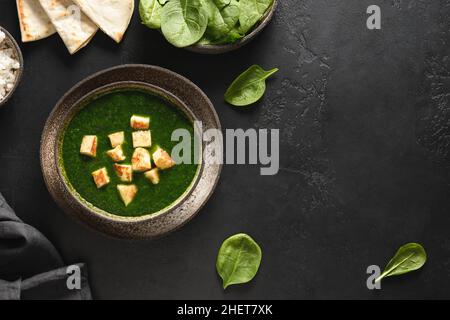 Palak Paneer servi avec du riz basmati sur fond noir.Cuisine végétarienne indienne à base d'épinards et de paneer.Copier l'espace.Vue de dessus. Banque D'Images