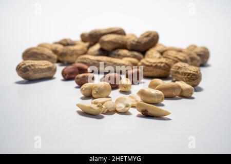 Ensemble d'arachides isolé sur fond blanc.Arachides entières et pelées. Banque D'Images