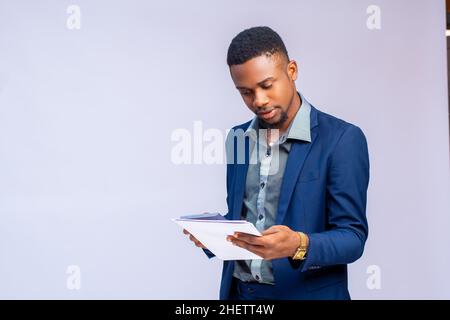 beau homme d'affaires africain isolé sur fond blanc calculatrice pour calculer la facture bancaire Banque D'Images