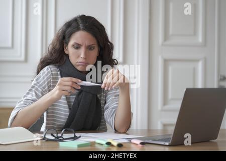 Triste malsaine italienne employée de bureau avec thermomètre se sentant malade et mal au travail Banque D'Images