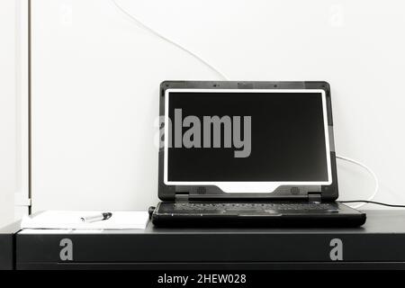 ordinateur portable noir avec écran ouvert devant le rack de serveurs Banque D'Images