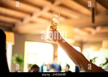 Bras levant un verre de champagne.Célébration, journée importante.Nouvelle année. Banque D'Images