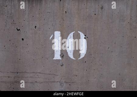 10, numéro rond imprimé en blanc sur un mur Banque D'Images